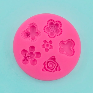 Macro detail of a pink silicone mold featuring intricate rose and butterfly relief shapes