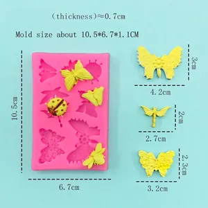 Pink silicone mold for butterfly and ladybug cakes with size markings on blue background