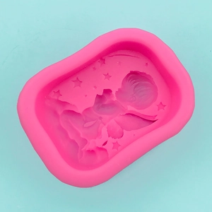 Detail of baby angel and star patterns inside a flexible pink silicone soap mold
