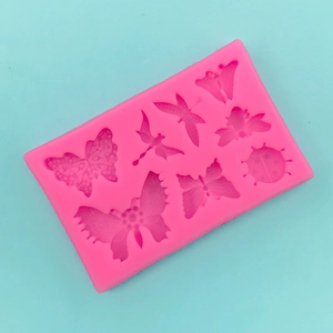 Detailed macro view of pink silicone mold with butterfly and ladybug shaped cavities