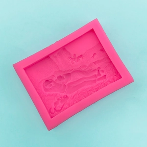Close-up of pink silicone mold featuring embossed deer and mountain landscape patterns