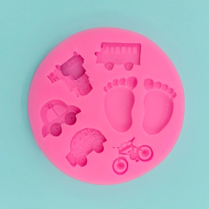 Top view of pink silicone mold with car, bus and footprint patterns on blue background