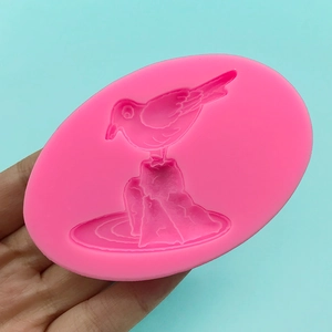 Pink oval silicone mold featuring a bird on rock design for DIY baking and crafts