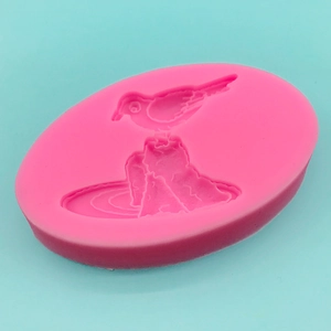 Pink silicone mold featuring a bird on rocks relief design for DIY baking and crafts