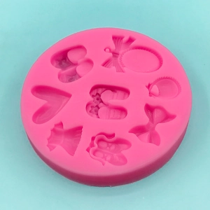 Pink silicone mold with heart, bow, and dress shapes for fondant cake decorating