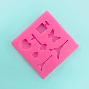 Dettaglio dello stampo in silicone rosa con forme di Torre Eiffel e farfalle