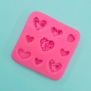 Dettaglio stampo in silicone rosa con cuori e fiocchi per cioccolato fatto in casa