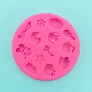 Macro view of pink silicone mold with baby-themed shapes like bottles and bibs