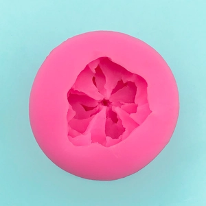 Detail showing bright pink silicone cake mold with multi-petal flower texture for baking