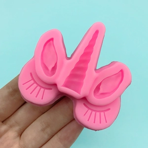 Pink silicone unicorn mold featuring horn, ears, and eyelashes for DIY fondant baking