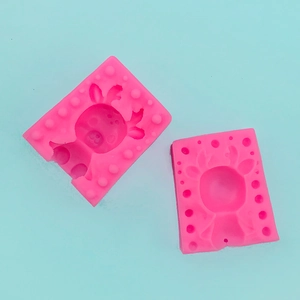 Macro detail of two pink silicone molds with 3D deer head designs on blue background