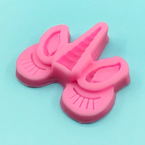 Pink silicone unicorn mold featuring spiral horn and eyelash details for DIY baking