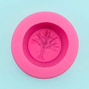 Detail view of pink round silicone mold featuring an intricate lavender floral relief