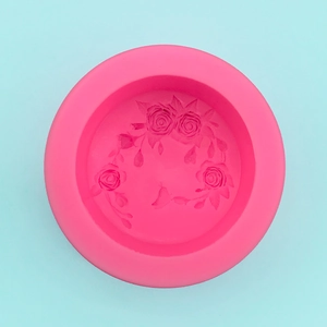 Macro detail of round pink silicone mold with intricate 3D rose and leaf patterns