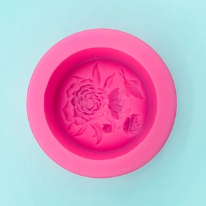 Close-up of pink silicone mold with detailed rose flower and butterfly carvings
