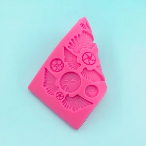 Pink silicone mold featuring wings and gear designs for DIY cake baking and crafts