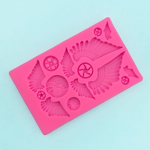 Detail of rose pink steampunk silicone mold with intricate wings and gear patterns