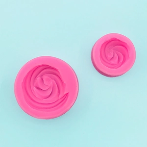 Top view of two pink spiral silicone molds for baking on a light blue background