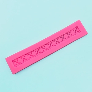 Detail of pink silicone flower lace mold with floral embossing for fondant cake border