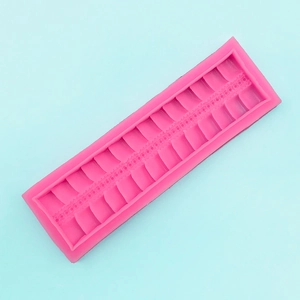 Macro detail of pink silicone border mold with vertical stripe and bead textures for cake DIY