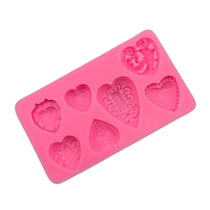 Pink heart-shaped silicone mold with varied embossed designs for DIY baking and crafts