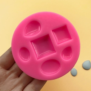 Pink silicone mold with geometric oval, square, and teardrop shapes for DIY jewelry
