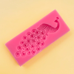 Macro shot of detailed peacock pattern inside a pink silicone mold for cake fondant