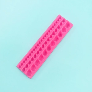 Detail macro view of pink silicone mold with drop shapes for cream fondant cake decoration