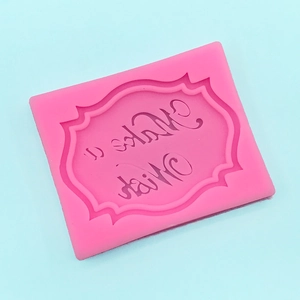 Close-up of pink silicone mold with Make a Wish text and elegant floral frame for baking