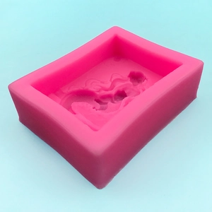 Pink rectangular silicone mold for handmade soap, chocolate, and resin crafts on blue backdrop