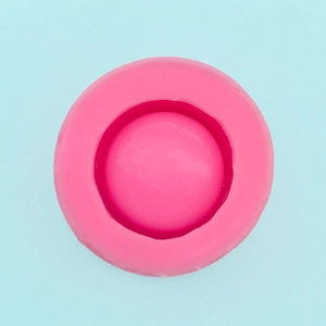 Top view of a round pink silicone mold for DIY soap and candles on a light blue surface