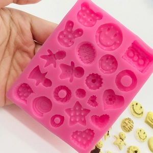 Pink silicone mold featuring 18 various shapes like smiley faces and gingerbread man designs
