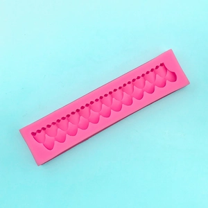 Macro shot of long pink silicone mold for pearl wave patterns on cake borders