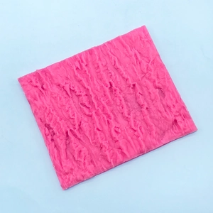 Macro shot of pink silicone fondant mold with detailed tree bark and rock texture
