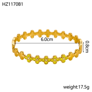 Detailopname van gouden klaverarmband met gele kristallen en maatspecificaties