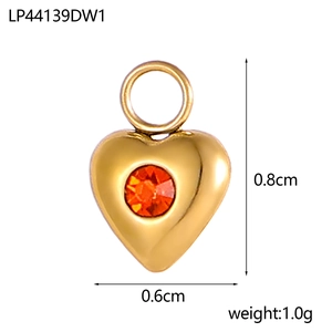 Detailliertes Makro eines Herzanhängers aus Gold mit orange-rotem Zirkonia-Inlay