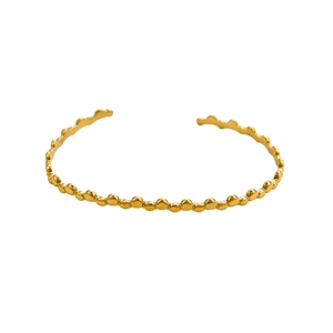 Detailed macro view of gold minimalist open cuff bracelet with textured organic bead design