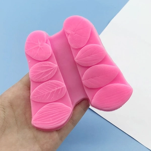 Pink leaf-textured silicone mold for fondant and clay DIY crafts held by hand