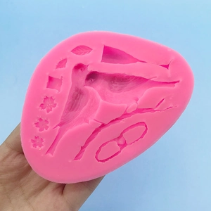 Pink silicone mold featuring magpie bird, flowers, and leaves for fondant and baking