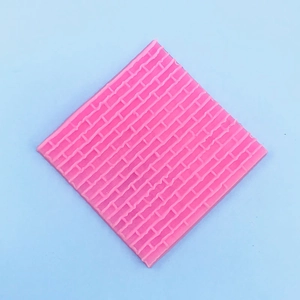 Dettaglio macro dello stampo quadrato in silicone rosa con trama di muro di mattoni 3D