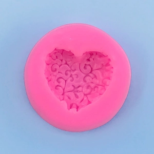 Detailed macro view of the pink silicone heart mold with intricate floral vine engraving