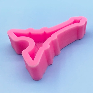 Pink silicone Eiffel Tower mold for DIY cake decorating on a light blue background