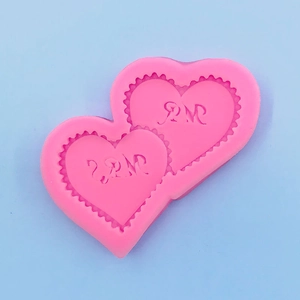 Detail of pink silicone heart mold with decorative lace edges for cake fondant decorating