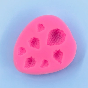 Macro shot of 6-cavity pink silicone mold featuring realistic strawberry seed textures