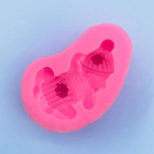 Makro-Detail einer rosa Silikonform mit schlafendem Baby und gestrickter Hut-Textur