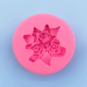 Detail of pink silicone mold featuring three intricate roses and leaf textures for baking