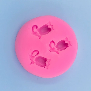 Macro detail of a pink silicone mold featuring three tulip-shaped cavities for DIY baking