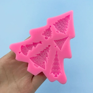 Pink silicone Christmas tree mold for DIY cake and chocolate decoration held in hand