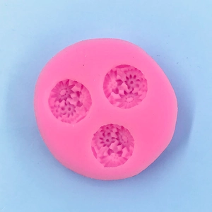 Detailed view of pink silicone mold with three daisy cavities for DIY cake decorating