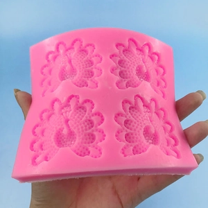 Pink silicone mold with four peacock floral embossed patterns for baking and DIY crafts
